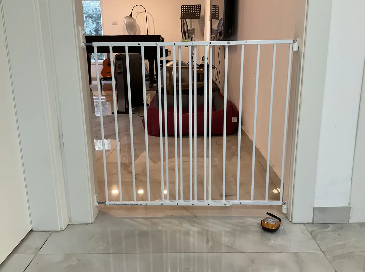 After: white baby safety gate installed across the living room doorway