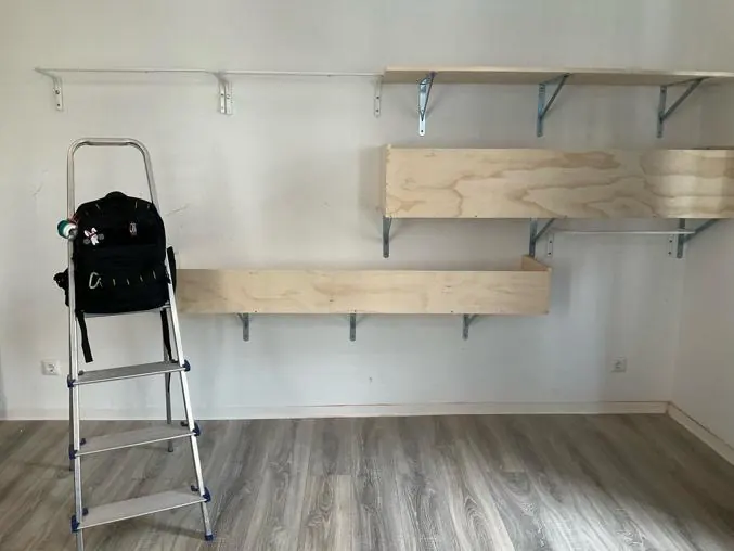 After: wooden wall shelves mounted on brackets along a living room wall